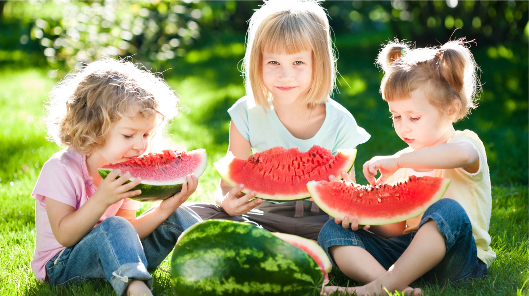 Three girls eating watermelon