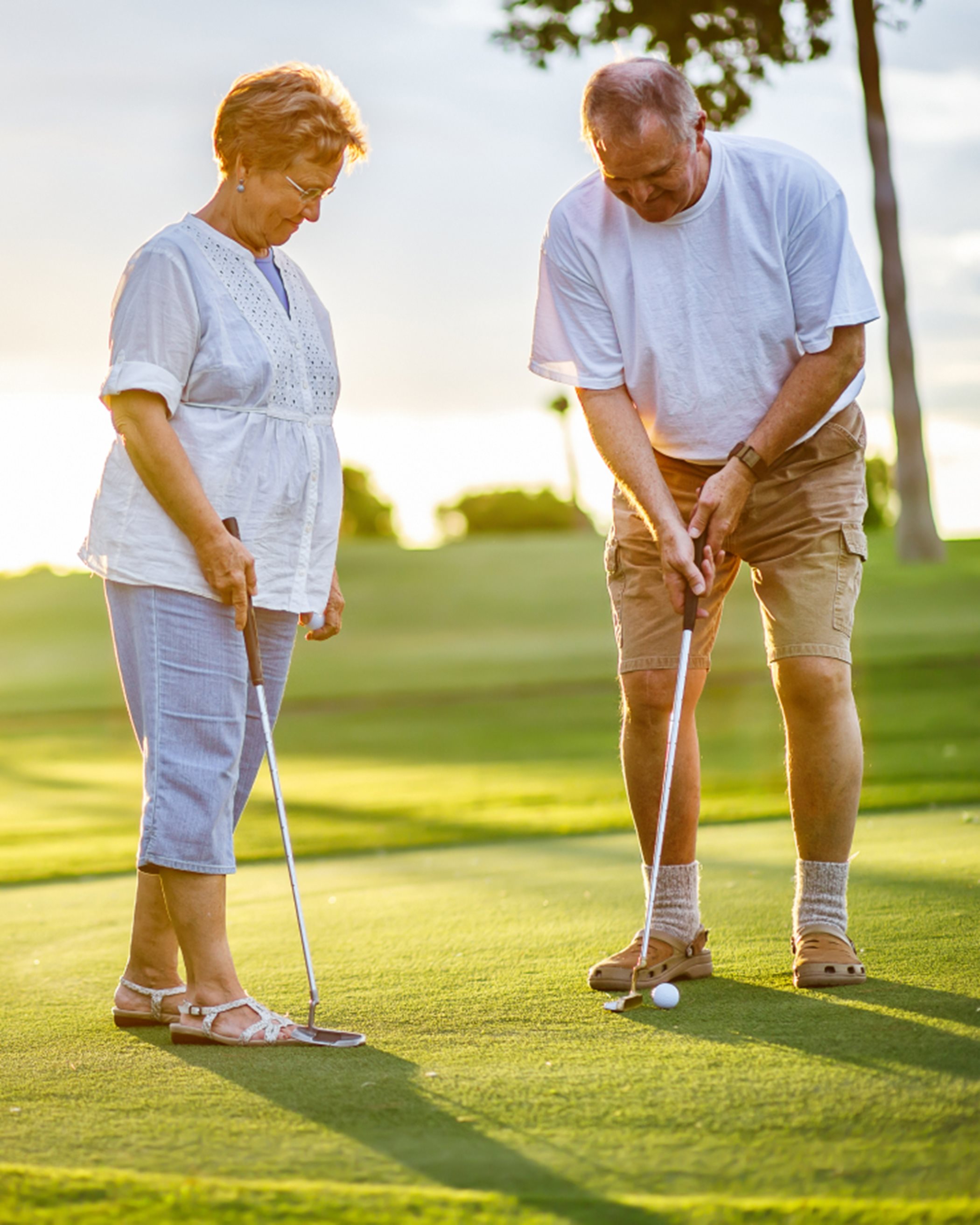 Two people putting on a golf course