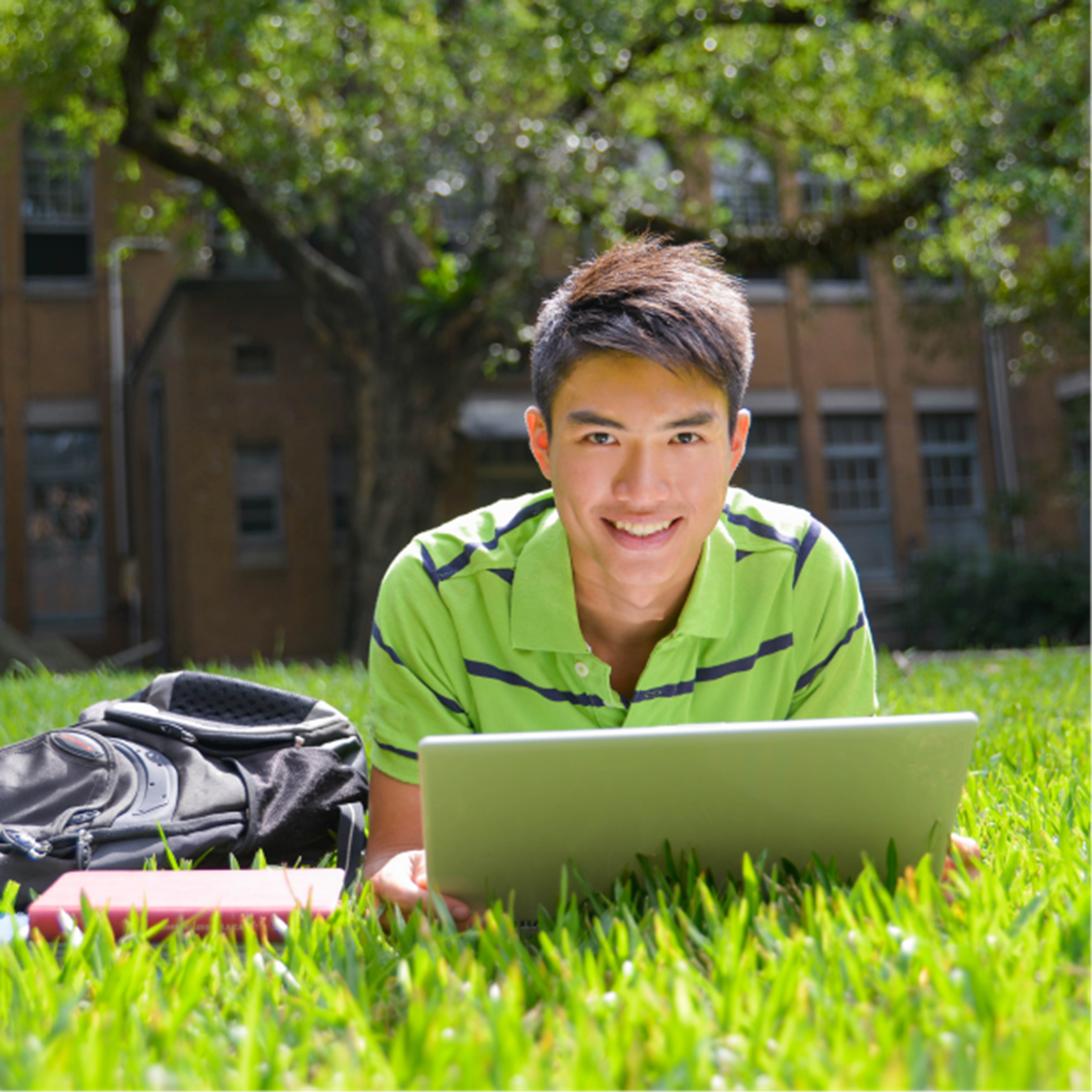 Student with laptop on grass