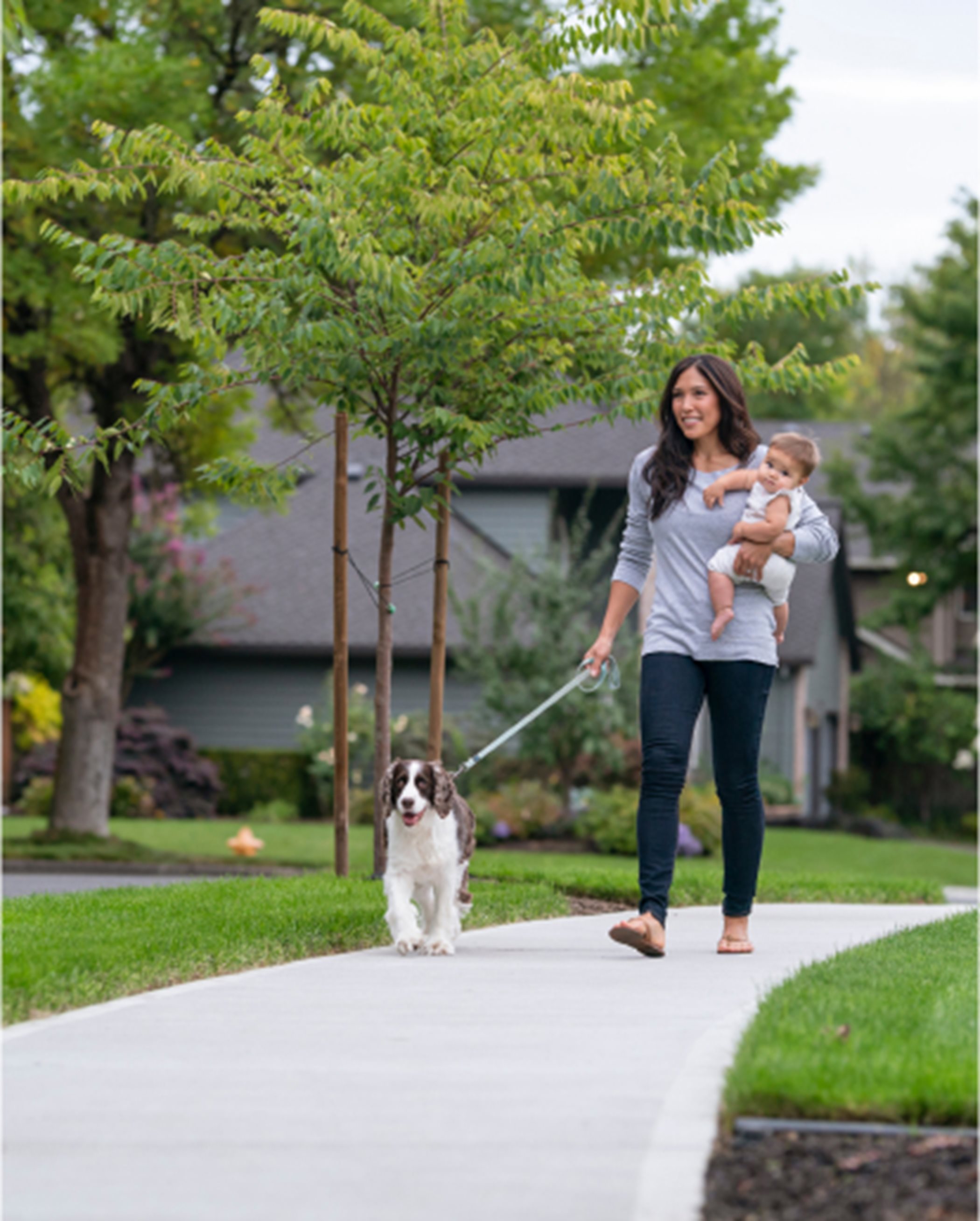 A person with a child walking with a dog