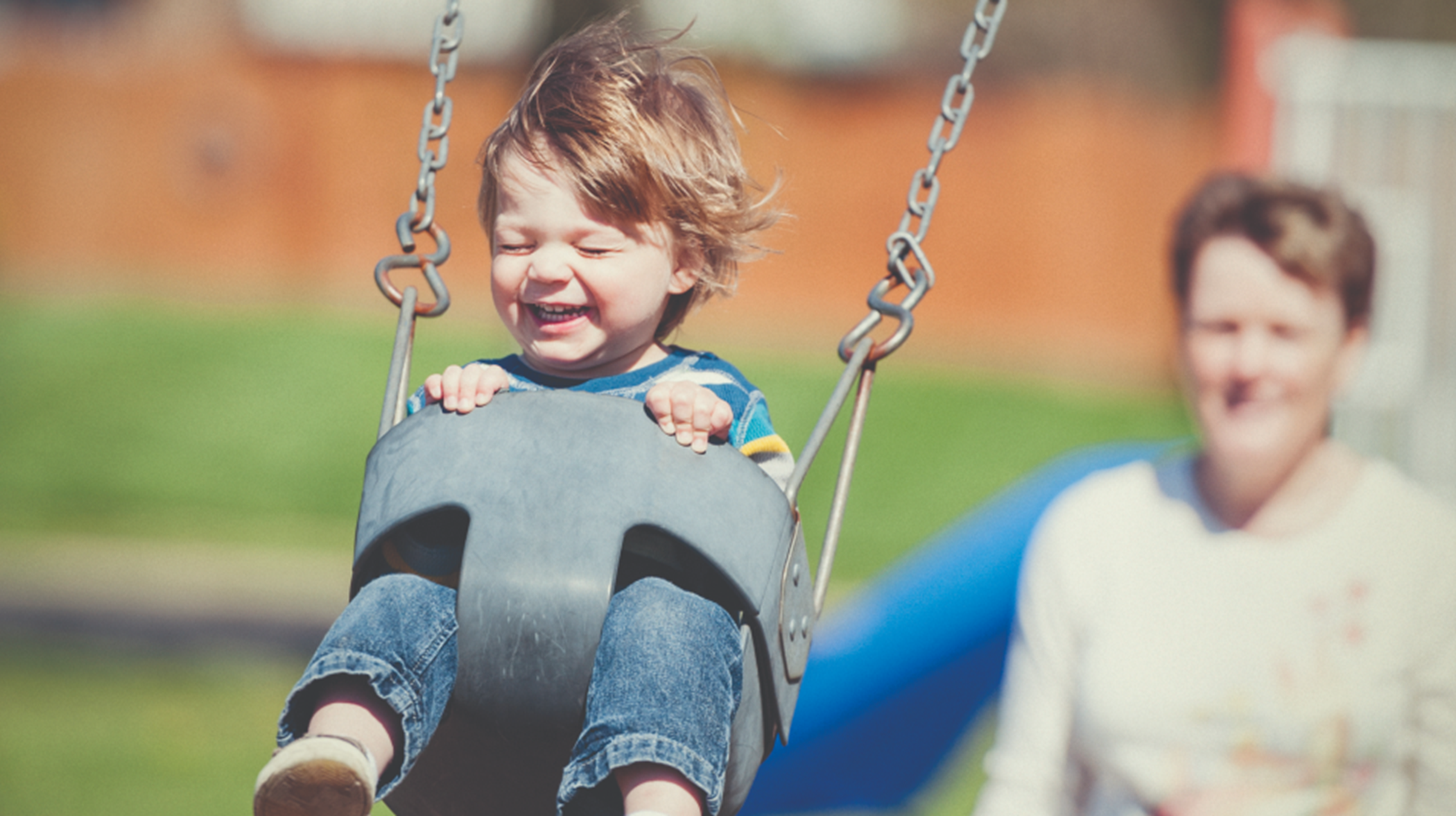 Kid on swingset in playground
