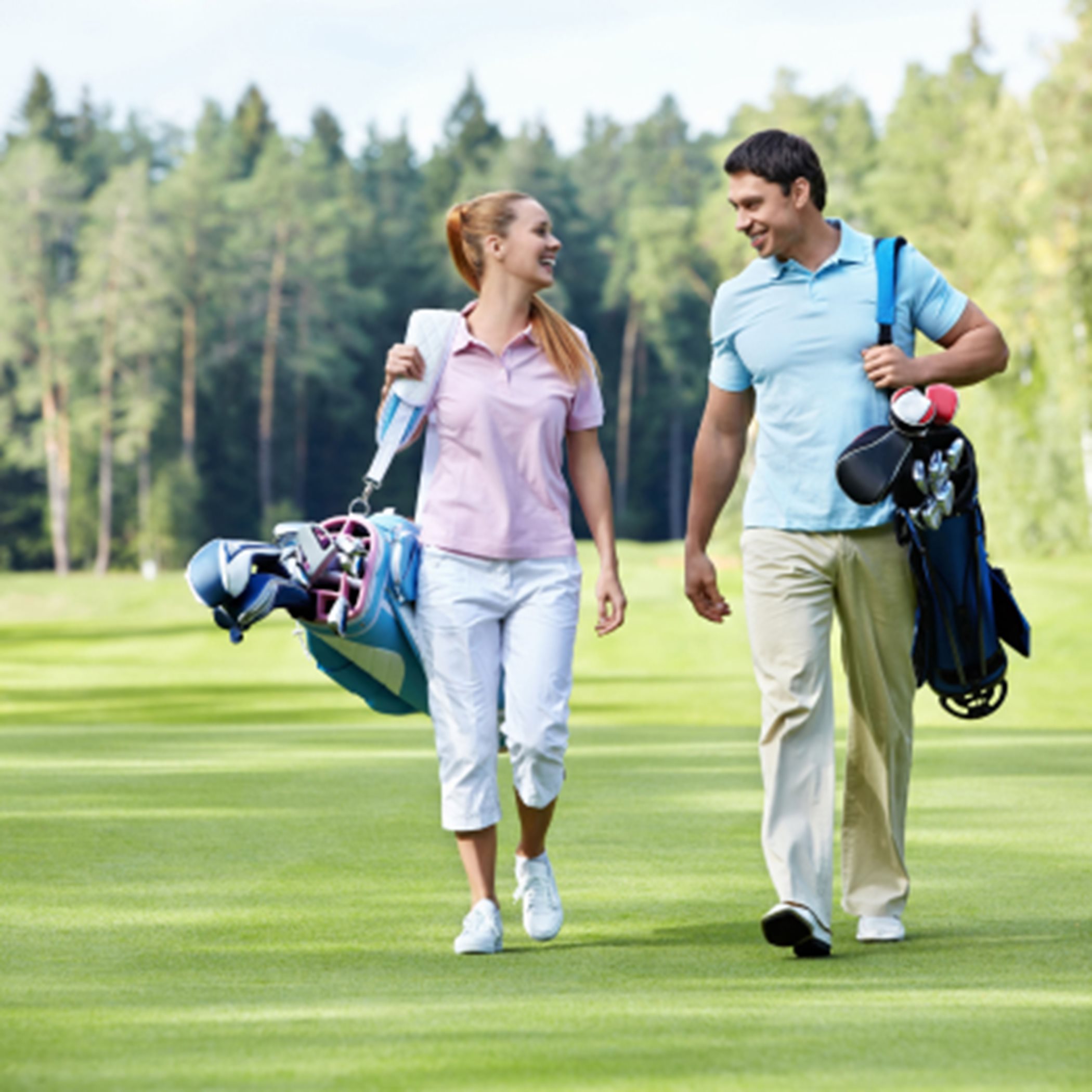 Two people walking on a golf course
