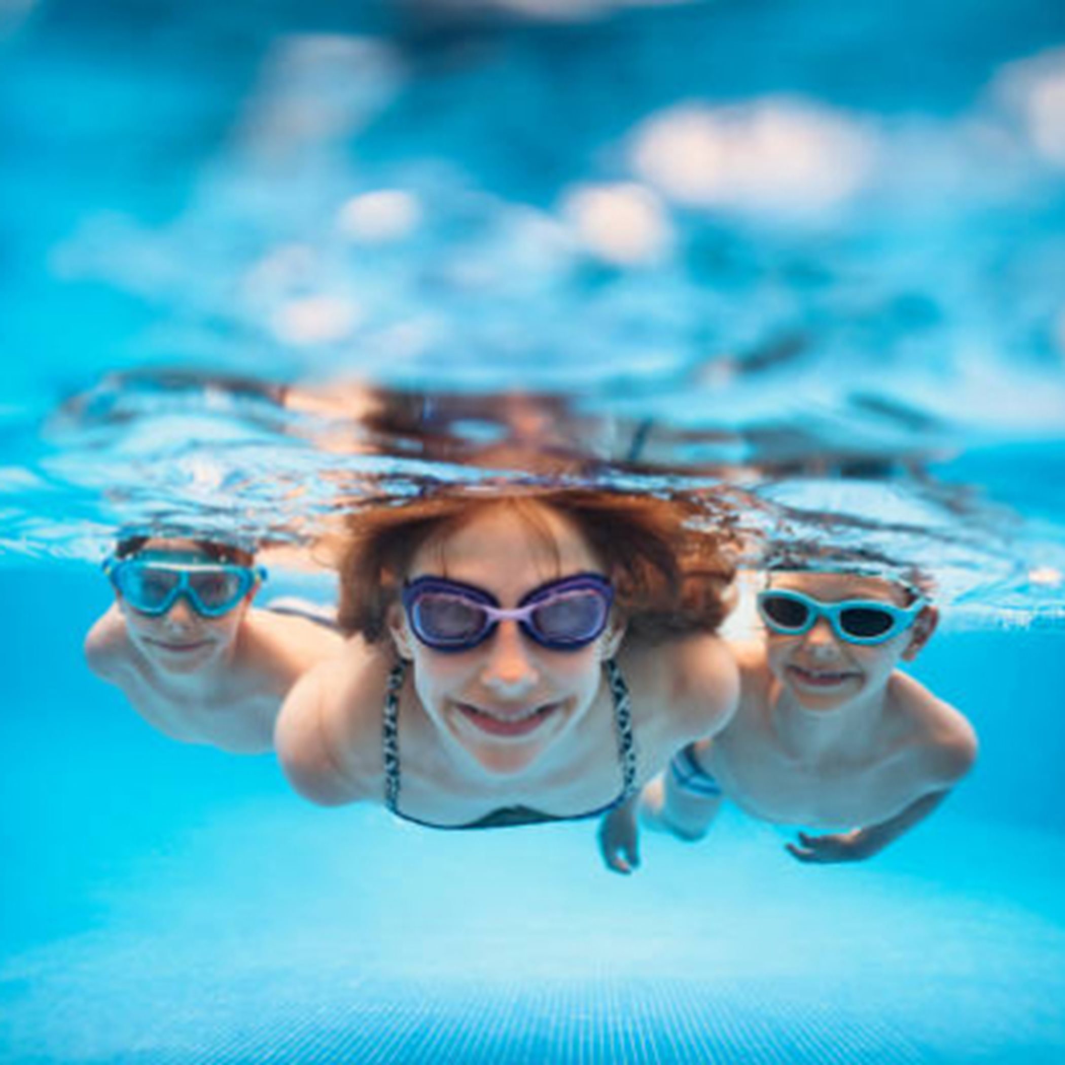 Three people swimming in a pool