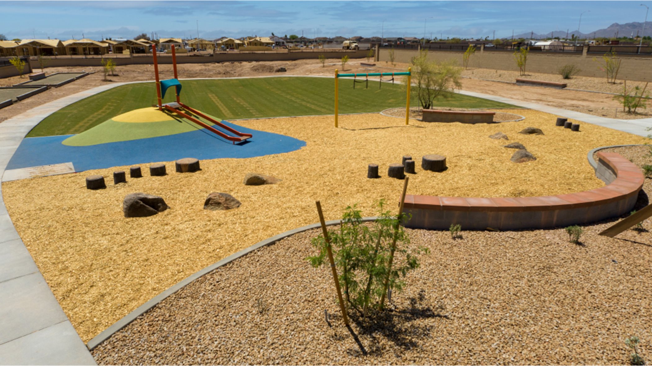 View of opposite side of playground with green space in the background