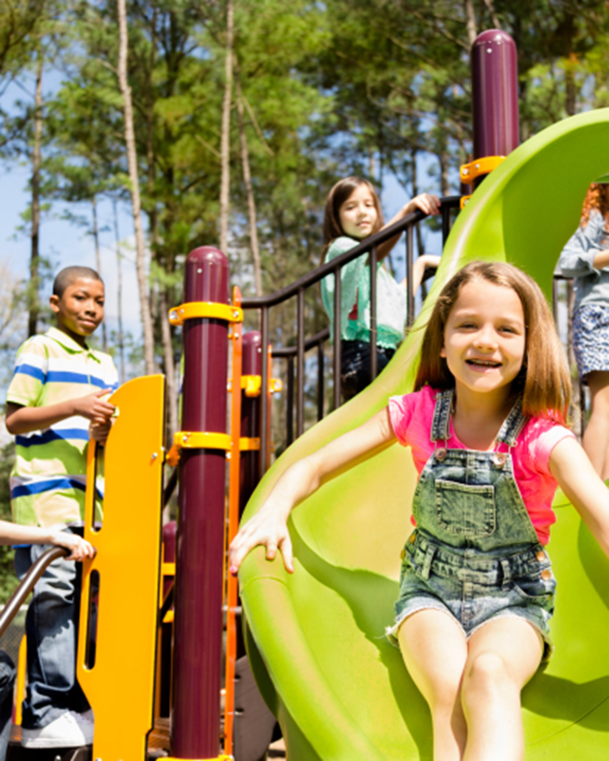 Smiling girl on playground slide