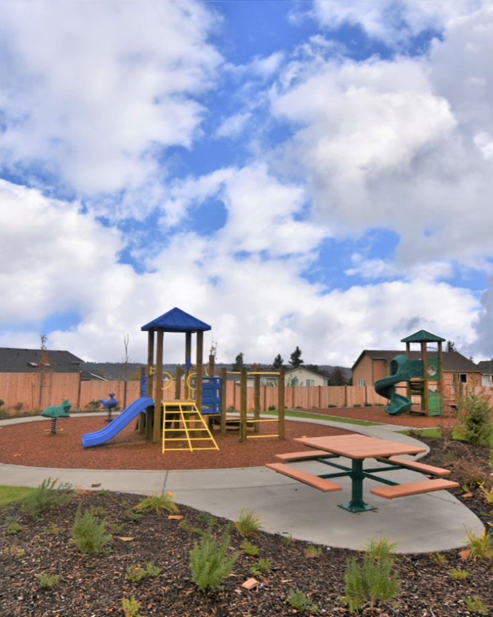 Playground with two jungle gyms and picnic tables