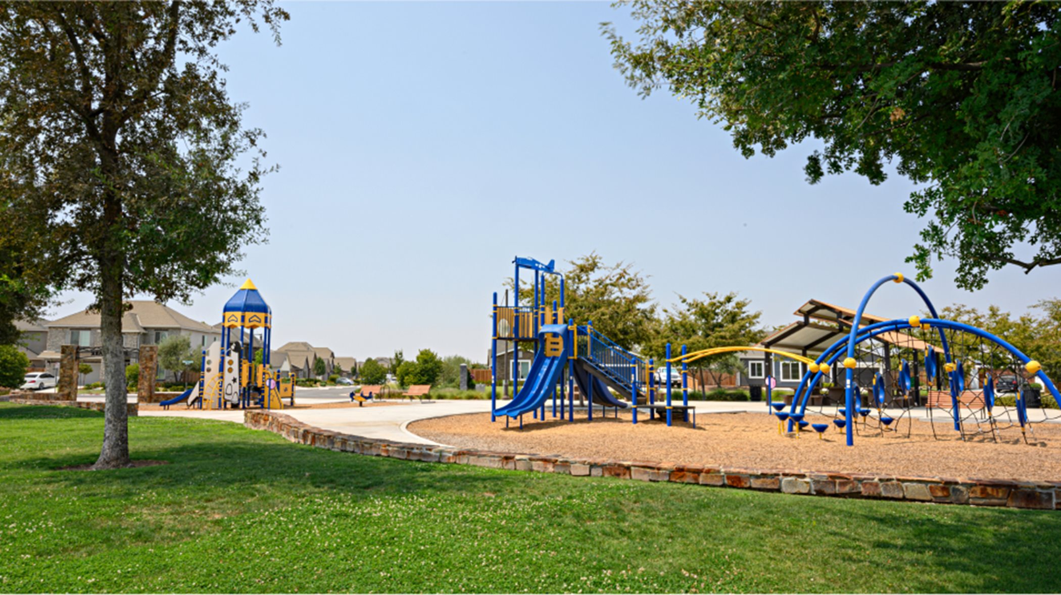 Play structure in wood chips surrounded by grass