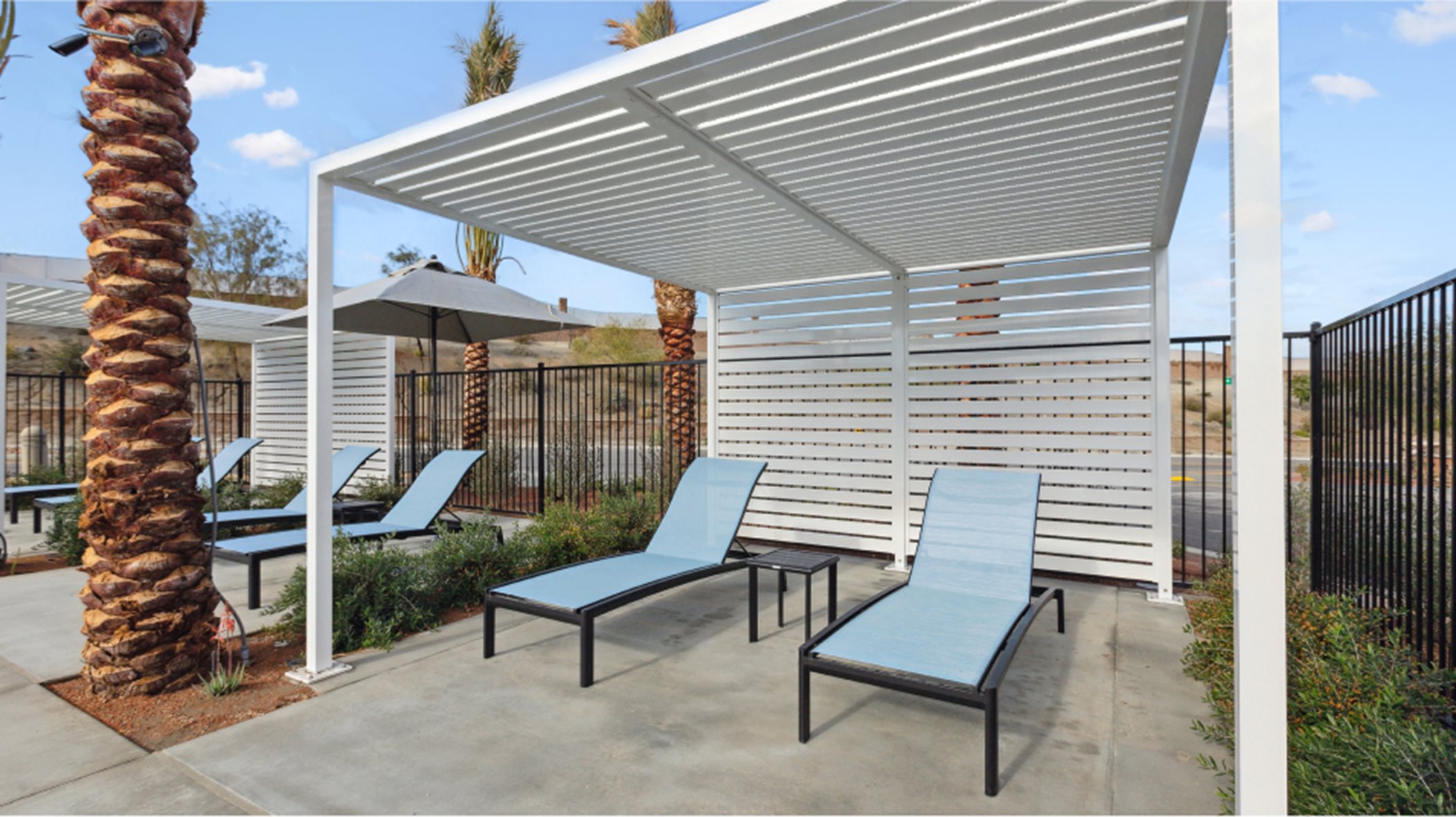 two lounge chairs beneath a poolside cabana