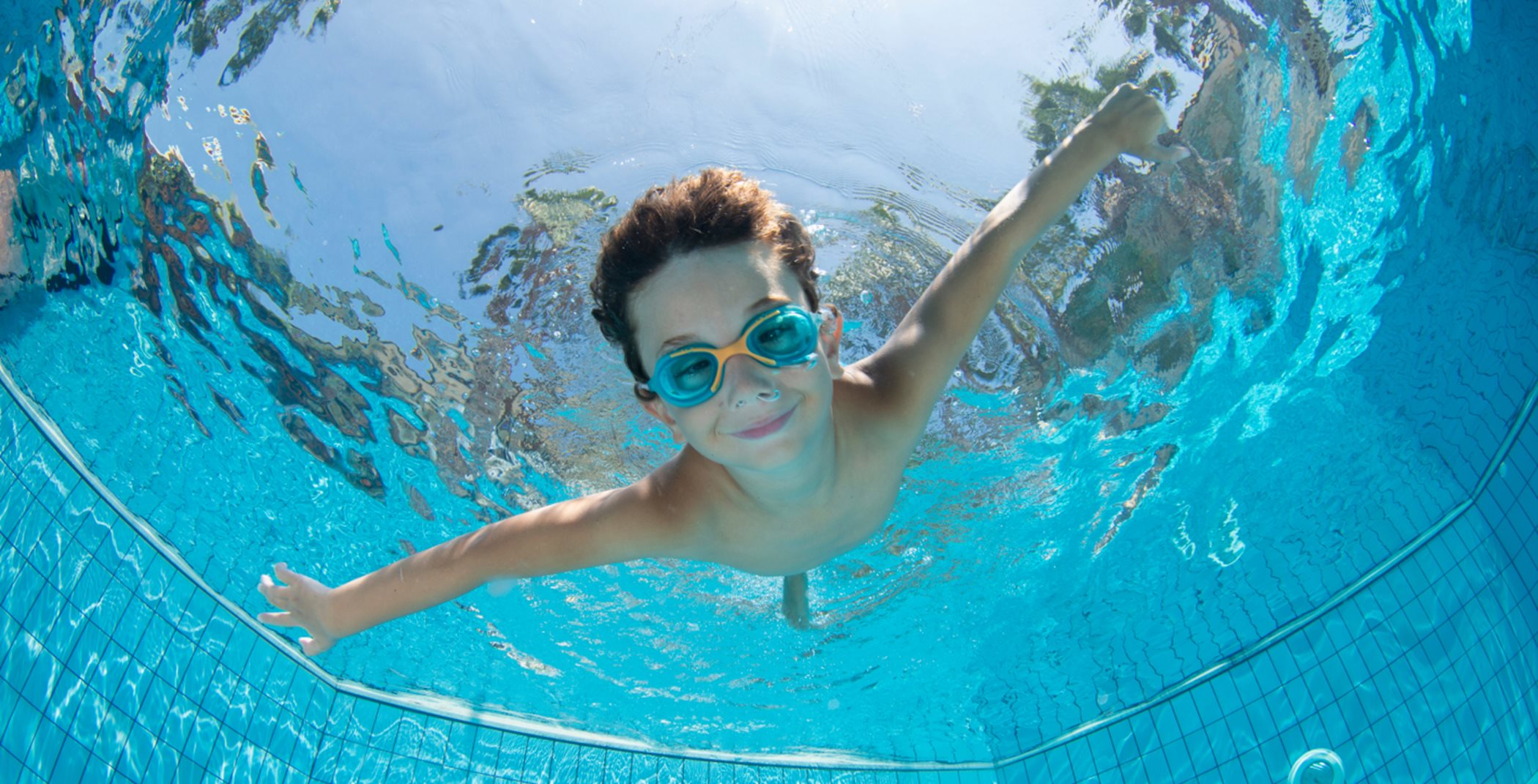 Child swimming underwater in a pool