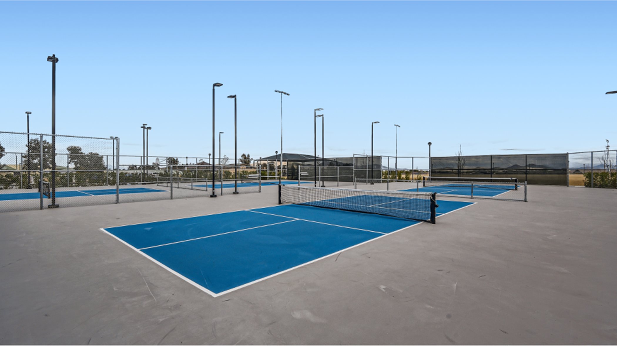 Blue tennis courts on a sunny day