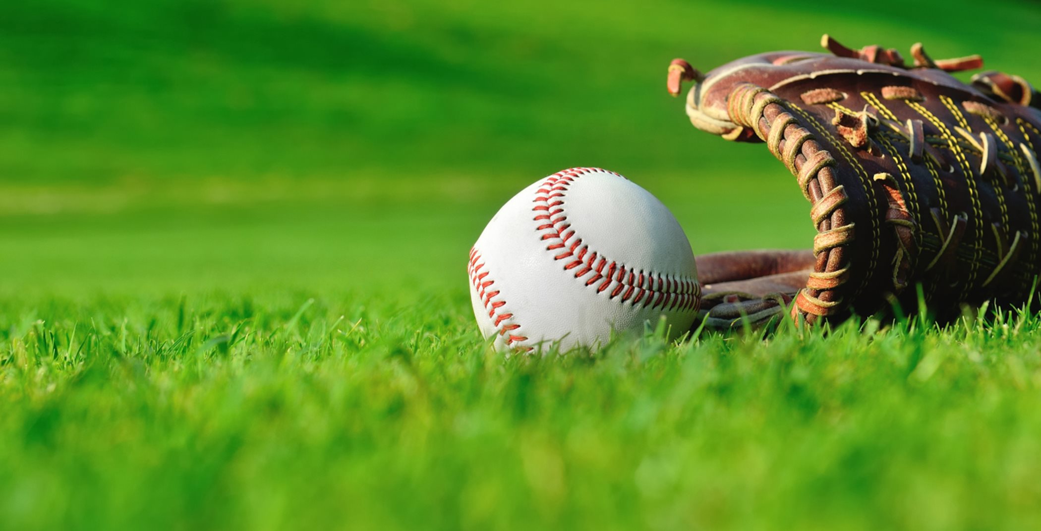 Baseball and mitt on a green field