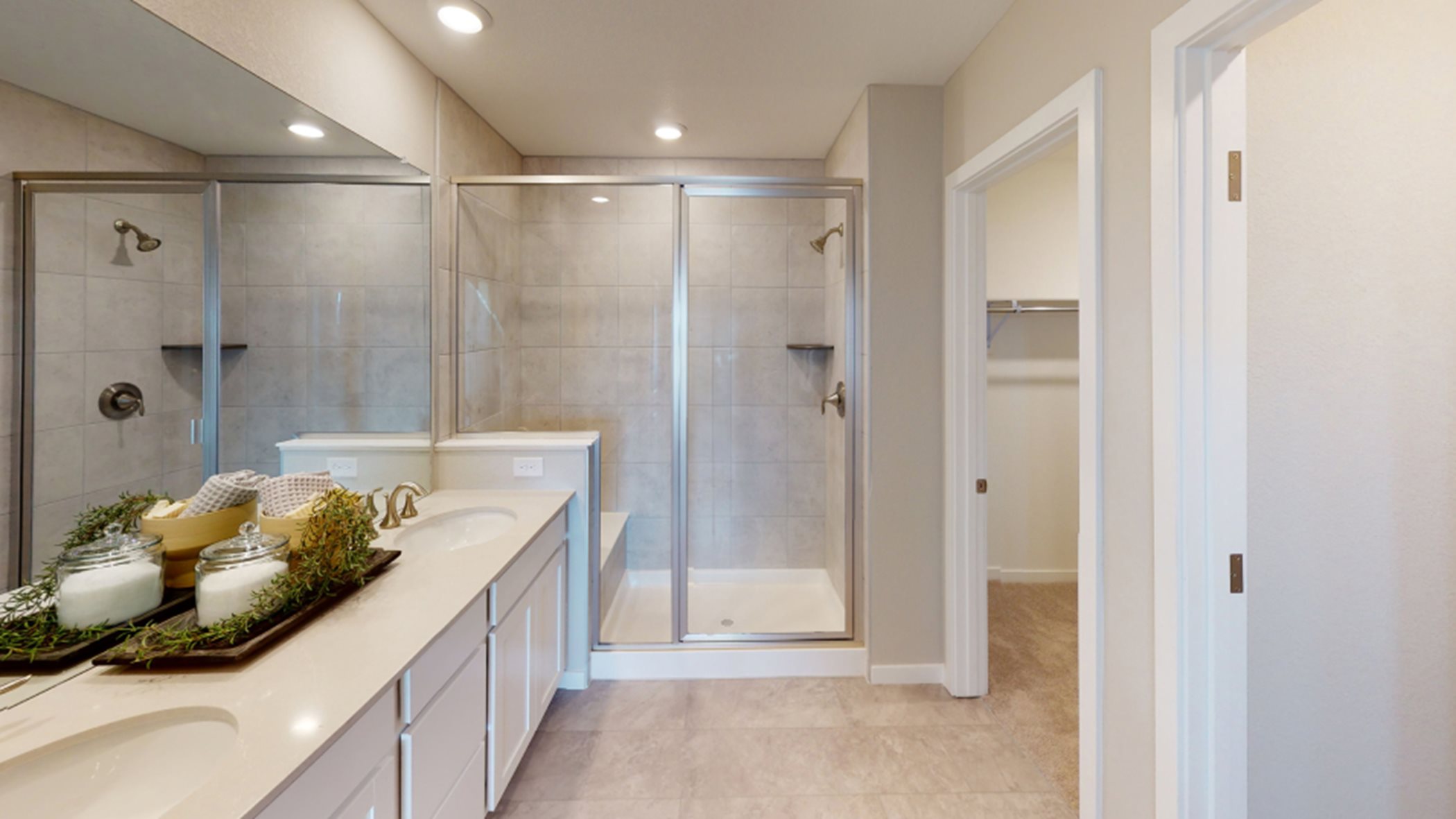 Owner's bathroom sinks, shower, and closet entrance