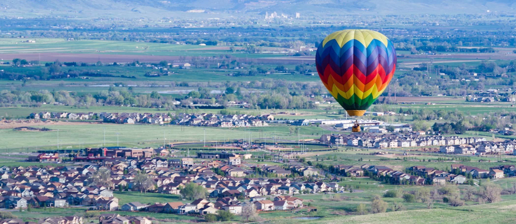 A hot air balloon flying over a town