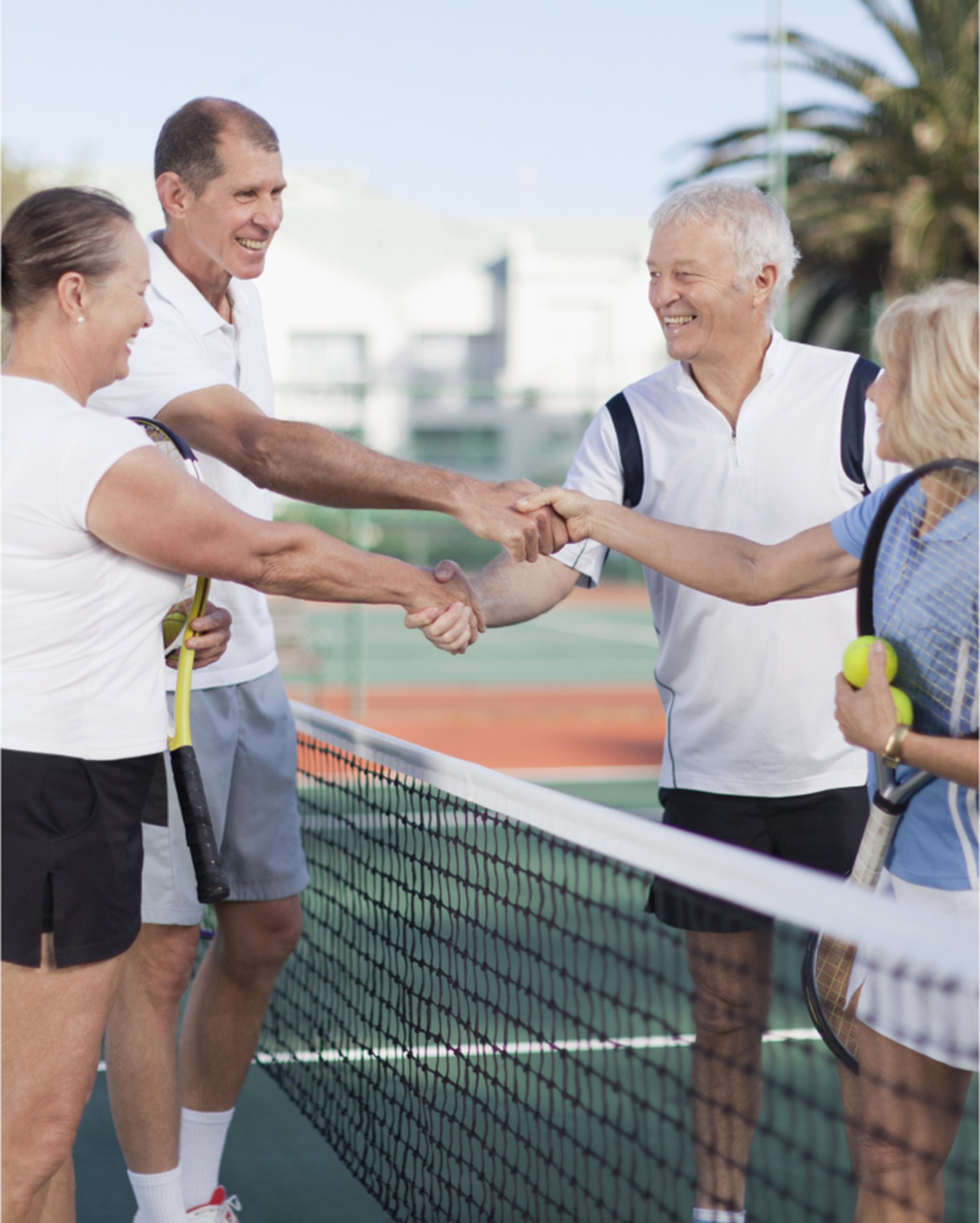 A group shaking hands on a tennis court