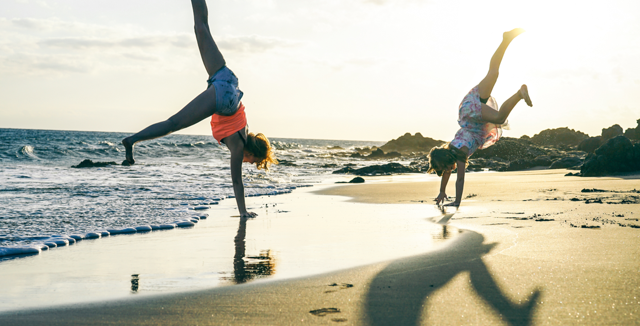 Mother and Daughter doing handstands on the beach