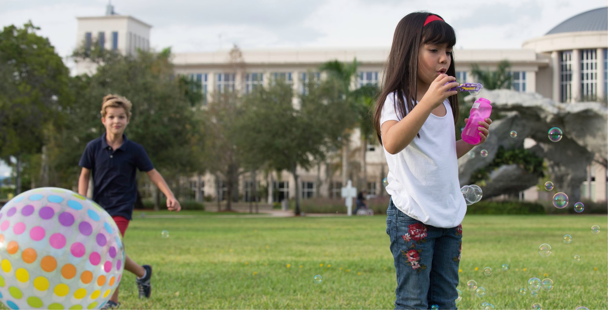 Little girl blowing bubbles in the park