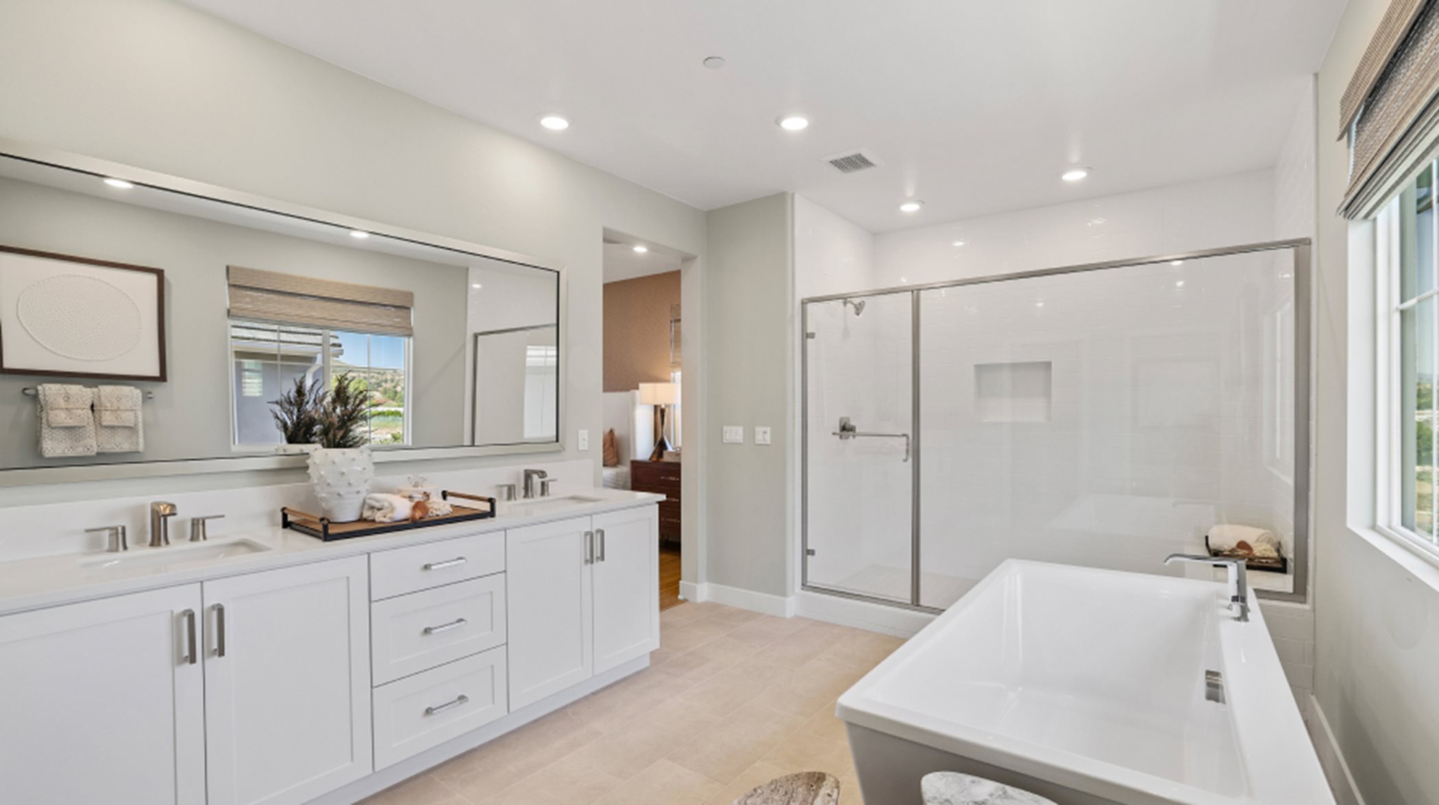 Furnished owner's suite bathroom with cabinetry, bath and shower