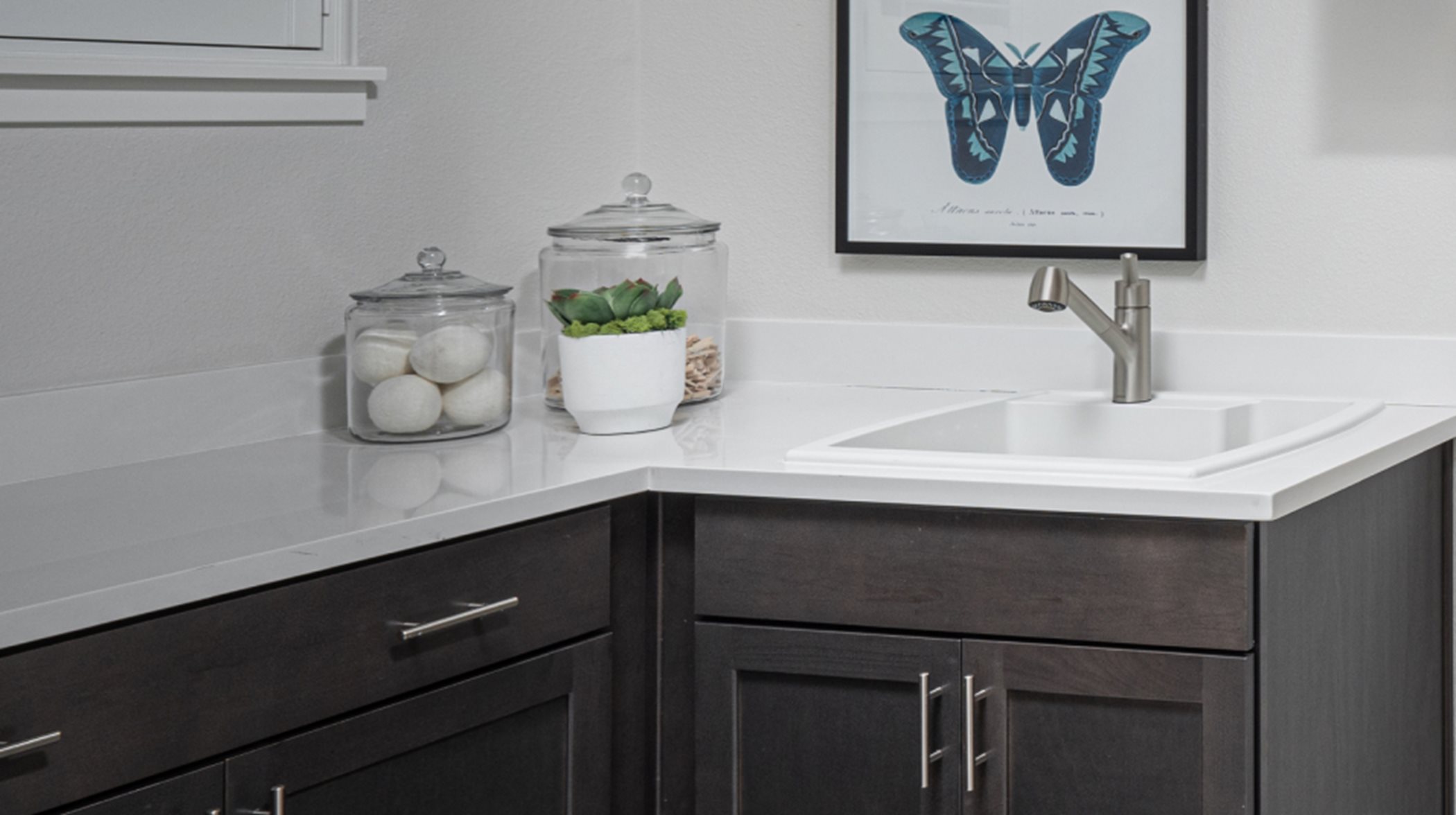 Ample countertop space for folding and a convenient sink are included in the laundry room 