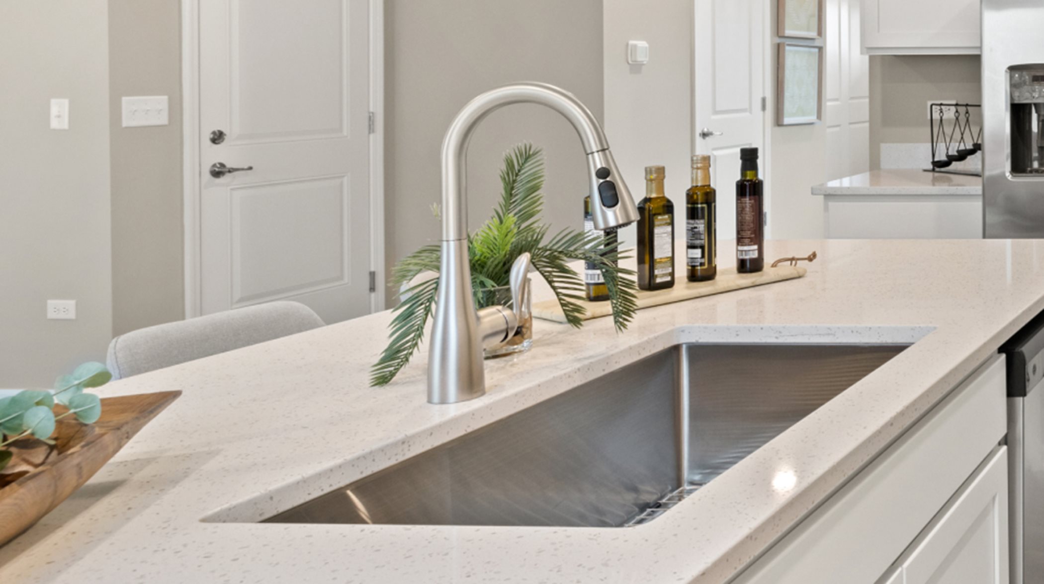Undermount stainless steel sink with designer-selected faucet and pull-out spray