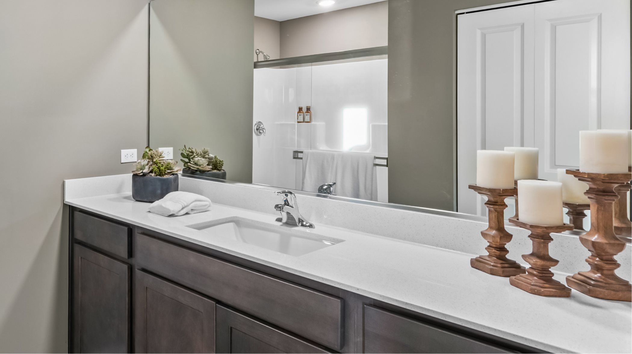 Quartz countertops, Moen® faucets and designer-selected cabinets at vanity 