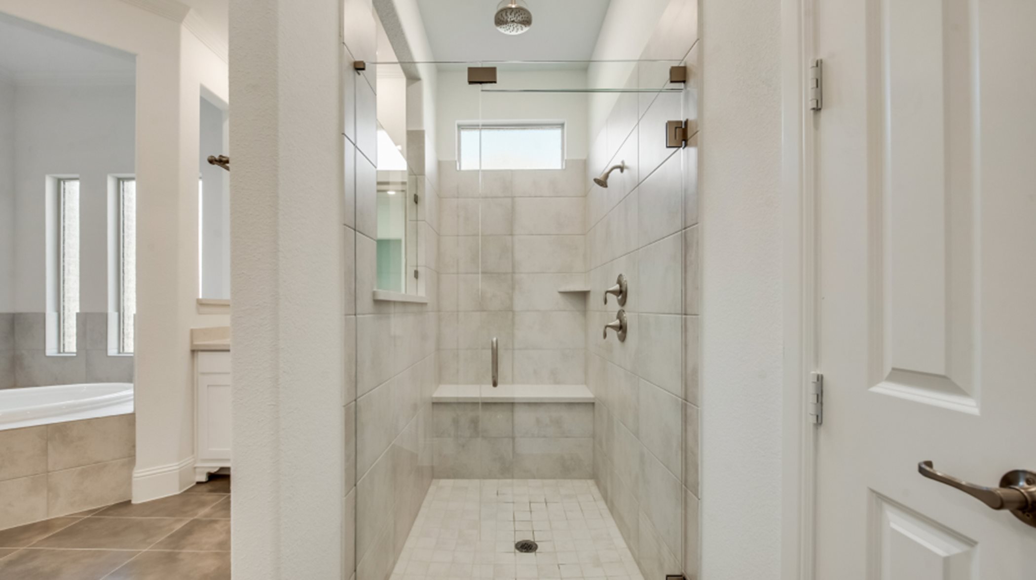 Walk-in shower with framed glass enclosure and built-in seating