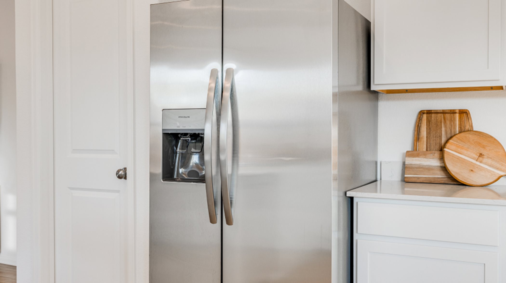 side-by-side refrigerator with a water and ice dispenser in stainless steel appliance package 
