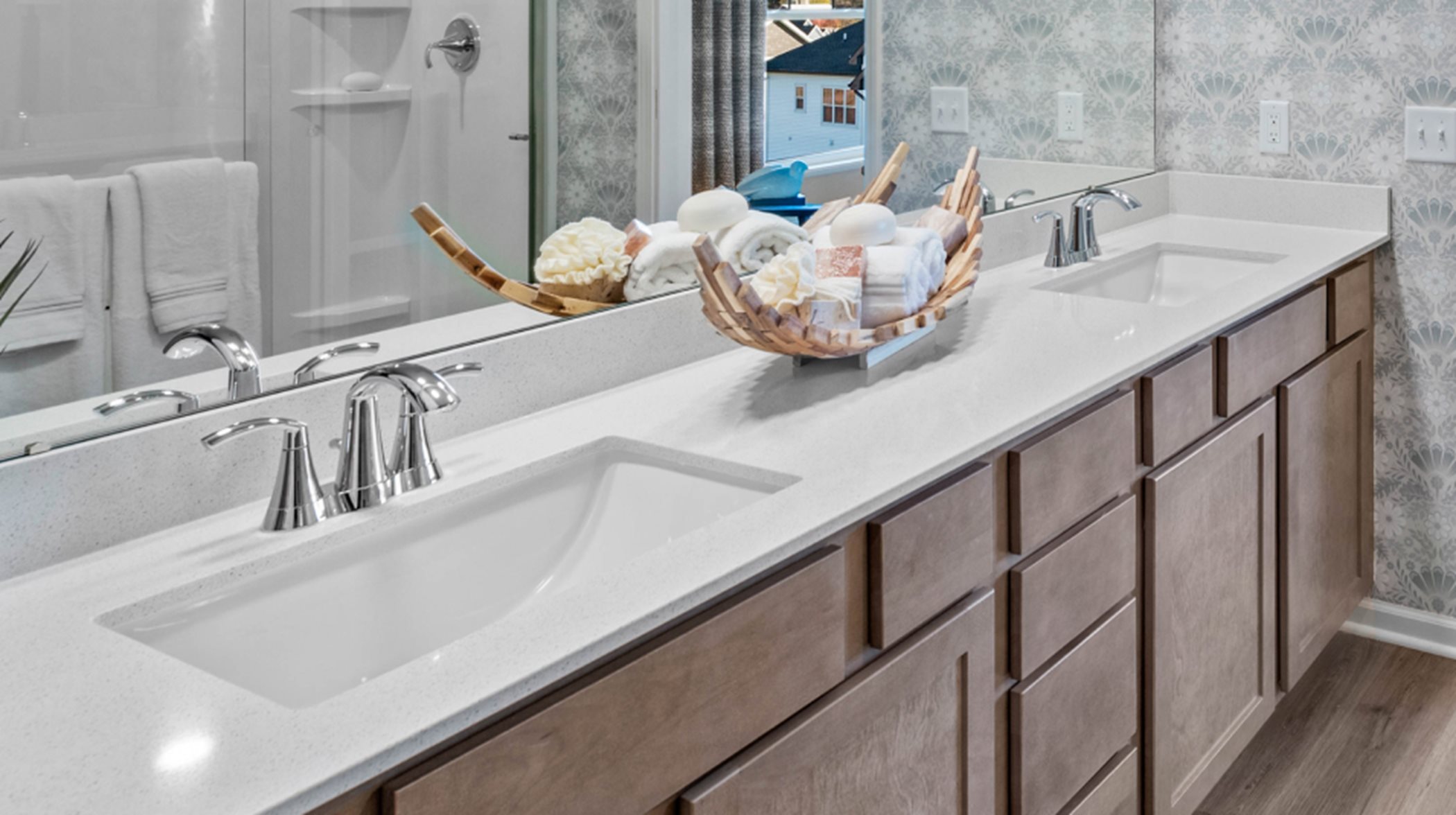 Dual rectangular undermount sinks with designer-selected countertops and Moen faucets